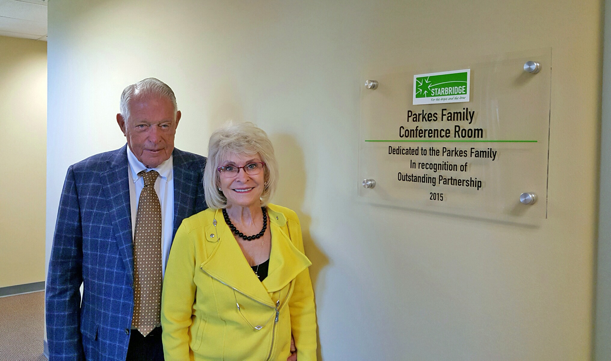 Walter and Barbara Parkes outside the Parkes Family Conference Room at Starbridge's main office